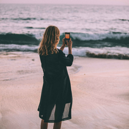 Woman taking a photo of the beach